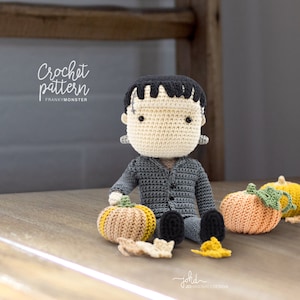 Puede incluir: Patrón de crochet para un amigurumi de monstruo de Frankenstein con pelo verde, sentado con tres calabazas naranjas. El patrón se llama "Franky Monster".