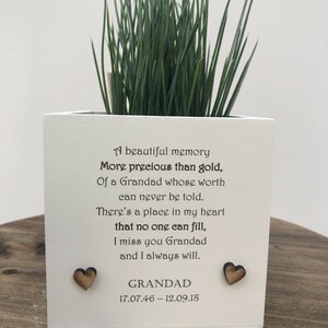 May include: A white square planter with green grass, featuring a heartfelt poem about a Grandad. Two wooden heart accents are on the front. The text includes the dates 17.07.46 - 12.09.18.