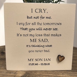 May include: A cream-colored wooden block planter with a green plant on top. The block has black text that reads "I CRY, but not for me...MY SON IAN 17.07.46-12.09.18." A small wooden heart is affixed to the front.