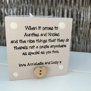 Puede incluir: Un bloque de madera beige claro con el texto "When it comes to Aunties and Uncles and the nice things that they do there's not a couple anywhere as special as you two. love Annabelle and Lucy x". Incluye un botón de madera.