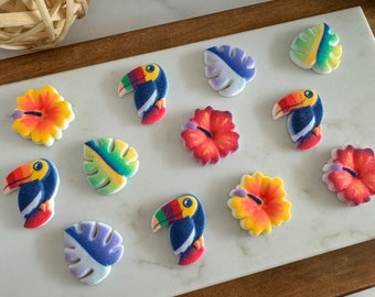 May include: A collection of colourful sugar cookies decorated with tropical themes. The cookies feature toucans, hibiscus flowers, and tropical leaves.