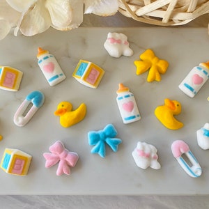 Könnte beinhalten: Sortiment an Babyparty-Kuchen-Toppern in verschiedenen Farben und Designs, darunter eine Babyflasche, eine Rassel, ein Schnuller, eine Ente und eine Schleife.