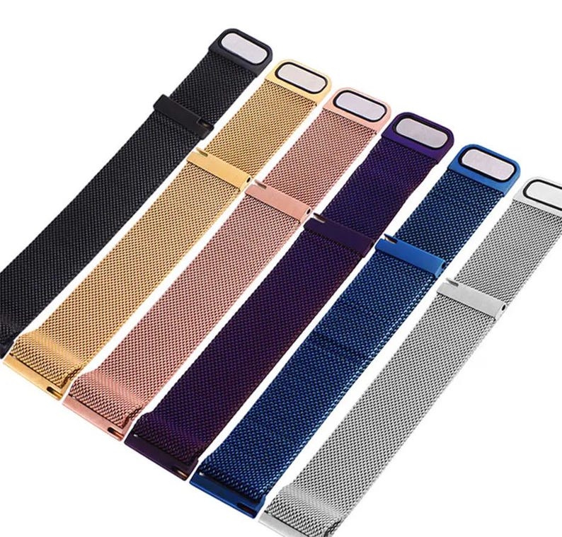 May include: An assortment of watch bands in various colors, including black, gold, rose gold, purple, blue, and silver. Each band features a mesh design and a magnetic clasp. The bands are angled diagonally across the frame.