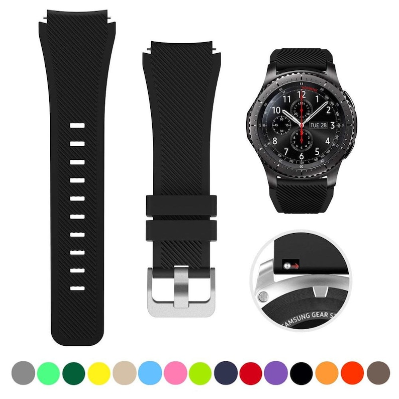 May include: A black silicone watch strap with a diagonal ribbed texture, featuring a silver-toned metal buckle and a quick-release pin mechanism. The strap is shown alongside a black smartwatch with a round analog-style face displaying the date.