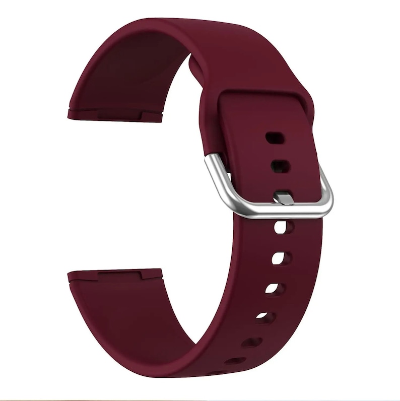 May include: A burgundy silicone watch band with a silver buckle. The band has multiple holes for adjusting the fit.