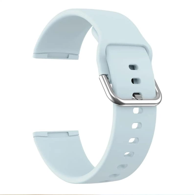 May include: A light blue silicone watch band with a silver buckle. The band has multiple holes for adjusting the fit.