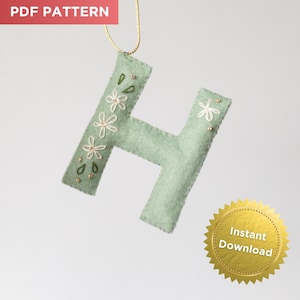 May include: A light green felt letter "H" with embroidered floral details and gold accents. The letter is suspended by a gold string. The words "PDF PATTERN" are in the top left corner, and a gold seal with "Instant Download" is in the bottom right.