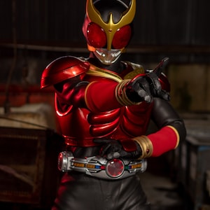 May include: A red and black action figure in a dynamic pose. The figure has a helmet with red eyes and a gold crest, a red chest plate, and black pants. The figure is wearing a silver belt with a red center.