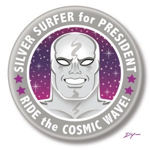 May include: A silver button with a purple and pink background featuring a silver surfer character with the text "SILVER SURFER for PRESIDENT RIDE the COSMIC WAVE!"