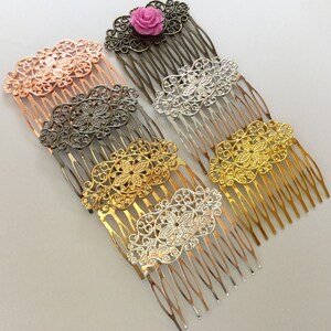 May include: Collection of decorative hair combs in various metallic finishes, including rose gold, silver, and gold. Each comb features an ornate filigree design with a central floral motif. One comb is topped with a pink rose.