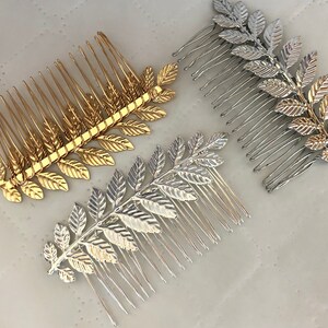 Op de afbeelding: Twee gouden en twee zilveren haar kammen met bladontwerpen. De kammen zijn ongeveer 10 cm lang en hebben een rij tanden aan &eacute;&eacute;n kant.