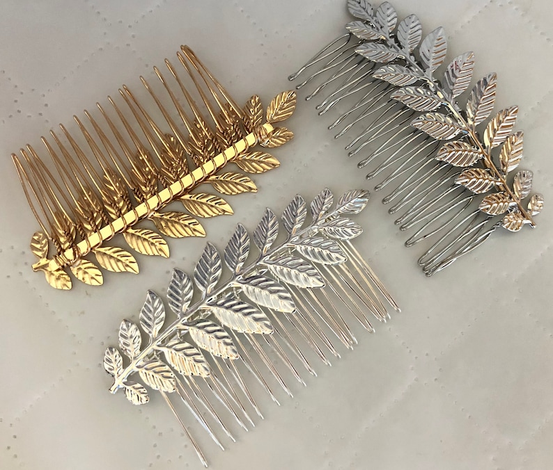 Op de afbeelding: Twee gouden en twee zilveren haar kammen met bladontwerpen. De kammen zijn ongeveer 10 cm lang en hebben een rij tanden aan &eacute;&eacute;n kant.