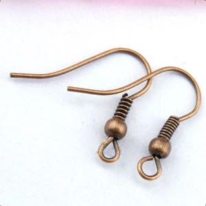 May include: Two antique bronze-colored earring hooks. Each hook features a curved wire design with a coiled spring and a small bead. The hooks are designed for jewelry making and crafting.