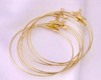 Puede incluir: Conjunto de seis aros de metal dorado, cada uno con un diámetro diferente. Los aros están apilados uno encima del otro.