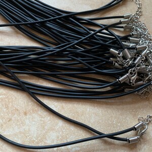 May include: A bulk pack of black elastic cord necklaces with silver spring ring clasps.