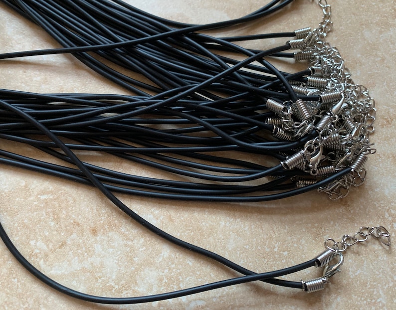 May include: A bulk pack of black elastic cord necklaces with silver spring ring clasps.