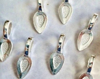May include: Eight silver-toned pendant bails with a teardrop shape. The bails have a loop at the top for attaching a pendant.
