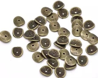 May include: A collection of antique gold-toned metal embellishments with a decorative sunburst design. The embellishments are scattered on a white surface.