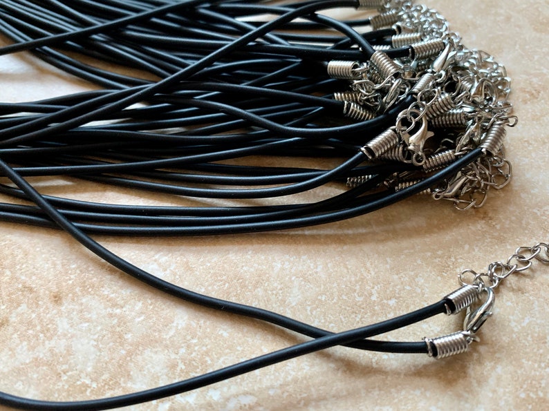 May include: A bulk pack of black elastic cord necklaces with silver spring ring clasps.