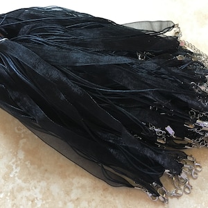 May include: A bulk pack of black ribbon with silver lobster clasps. The ribbon is made of a sheer, delicate material and is perfect for crafting or jewelry making.
