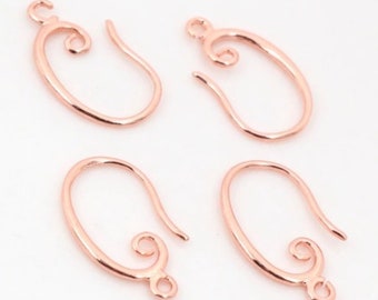 May include: Four rose gold earring hooks with a decorative swirl at the top. The hooks are oval shaped and have a smooth finish.