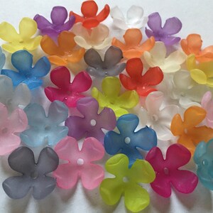 May include: A collection of translucent, five-petal flower beads in various colors, including yellow, purple, orange, pink, and blue. Each bead has a small hole in the center, suitable for stringing. These beads are ideal for jewelry making and craft projects.