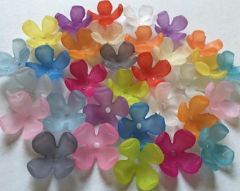 May include: A selection of translucent, five-petal flower beads in a range of colours, such as yellow, purple, orange, pink, and blue. Each bead has a small hole in the centre, suitable for stringing. These beads are ideal for jewellery making and craft projects.