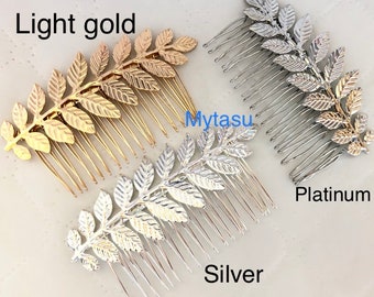 May include: Three hair combs with a leaf design. The combs are in light gold, silver, and platinum.