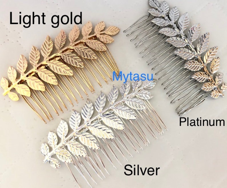 Op de afbeelding: Drie haar kammen met een bladontwerp. De kammen zijn in licht goud, zilver en platina.