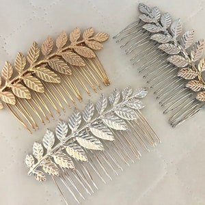 Op de afbeelding: Drie gouden en zilveren haar kammen met een bladontwerp. De kammen zijn gemaakt van metaal en hebben een delicate, vrouwelijke uitstraling.