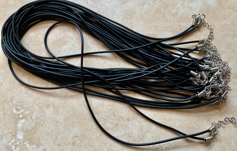 May include: A bulk pack of 20 black elastic cord necklaces with silver spring ring clasps. Each cord is approximately 18 inches long.