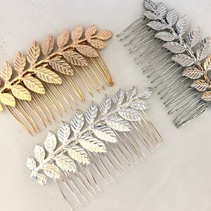 Op de afbeelding: Drie gouden en zilveren haar kammen met bladontwerpen. De kammen zijn gemaakt van metaal en hebben een delicate, vrouwelijke uitstraling.