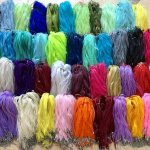 May include: A collection of colorful ribbon spools in various shades of blue, green, purple, pink, yellow, orange, and red. The ribbon is arranged in rows and is ready to be used for crafting projects.