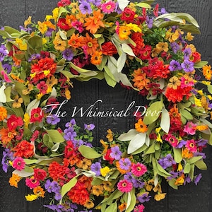 May include: A colorful floral wreath with orange, yellow, pink, purple, and green flowers. The wreath is made of silk flowers and greenery and is perfect for adding a touch of spring to your home decor.