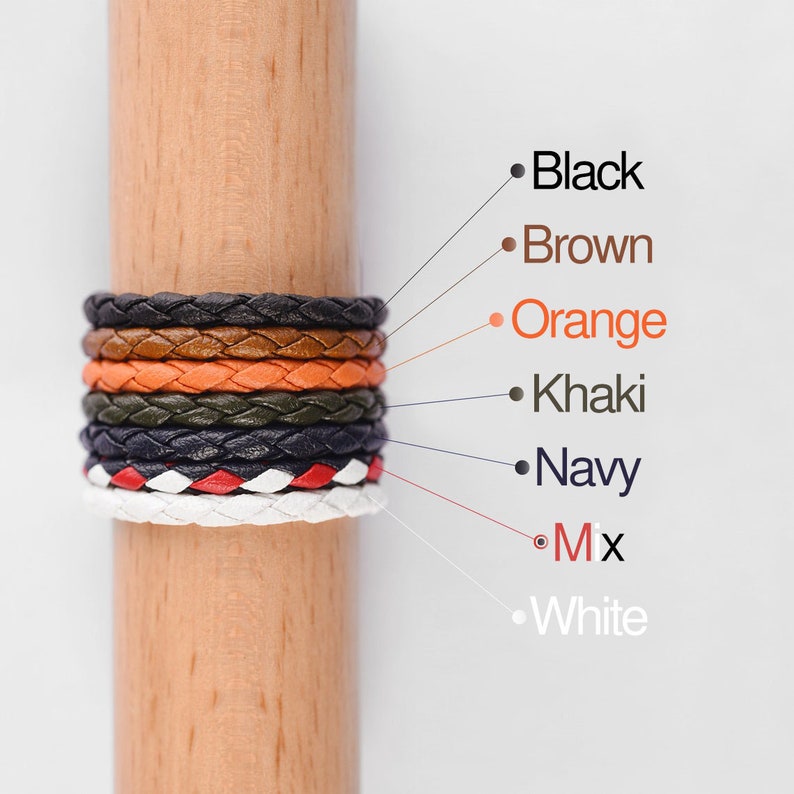 May include: A stack of braided leather bracelets in various colors, including black, brown, orange, khaki, navy, white, and a mix of colors. The bracelets are displayed on a wooden dowel.