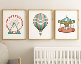 May include: Three framed watercolor prints featuring amusement park themes. The prints depict a Ferris wheel, a hot air balloon, and a carousel. The Ferris wheel is red and teal, the balloon is teal and coral, and the carousel is teal, brown, and red.