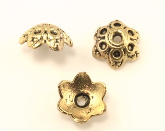 Puede incluir: Tres tapas de cuentas de metal dorado con un diseño en forma de flor. Las tapas tienen un pequeño agujero en el centro para enhebrar.