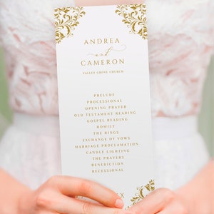 May include: A wedding ceremony order of service with gold ornate designs and the names Andrea and Cameron printed in cursive. The order of service lists the order of events for the ceremony, including the prelude, processional, opening prayer, old testament reading, gospel reading, homily, the rings, exchange of vows, marriage proclamation, candle lighting, the prayers, benediction, and recessional.