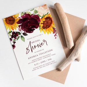 May include: A white bridal shower invitation with a watercolor floral design featuring burgundy roses and yellow sunflowers. The text reads "Please join us for a Bridal Shower in honor of Andrea Tollefson Anna Baxter's Residence 629 Charles Drive Burleson, Texas 8.23 20XX 3PM Please reply by August 19th Anna: 107-555-1212 (Text or Call)"