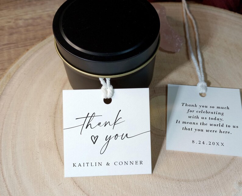 Op de afbeelding: Witte bedankkaartjes met zwarte kalligrafie die "Dank je wel" met een hartje en de namen "Kaitlin & Conner" zegt. Het tweede kaartje heeft de tekst "Bedankt dat je met ons hebt gevierd. Het betekent de wereld voor ons dat je er was. 8.24.20XX".
