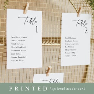 May include: White printed table cards with guest names and table numbers 1 and 2, clipped to a gold wire grid. The word "Table" is written in elegant script. The text "PRINTED *optional header card" is at the bottom.