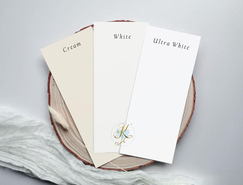 Op de afbeelding: Drie papierstalen op een houten oppervlak. De stalen zijn gelabeld met "Cr&egrave;me", "Wit" en "Ultra Wit".
