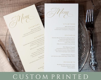 May include: Two ivory-colored menus with gold calligraphy lettering. The menus list starters, entrees, and desserts. The text on the menus reads "Menu", "Starters", "Entrees", "Desserts", "Baby Green Salad", "Chicken Breast Sauteed in Marsala Wine", "Filet Mignon", "Stuffed Poblano Pepper", "Wedding Cake & Groom's Cake", "Viennese Dessert Tables", "Donut Buffet".