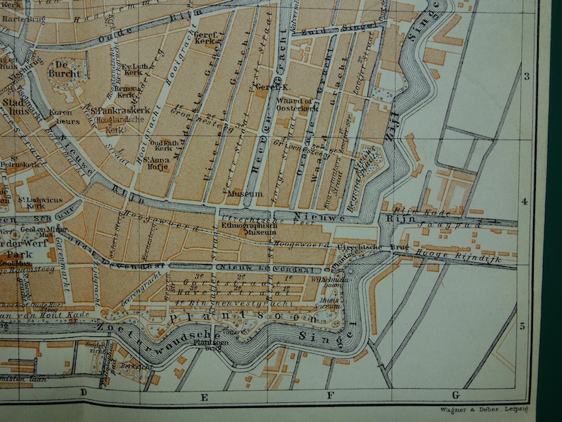 May include: A detailed vintage map of a city, featuring streets, canals, and buildings in shades of brown and beige. The map includes text labels and grid lines, with a watermark in the bottom right corner. The map is a historical document.