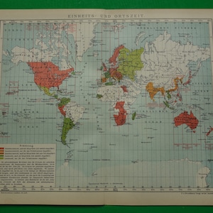 May include: A vintage world map depicting time zones in various colours. The map is titled "Einheits- und Ortszeit" and includes a key explaining the different time zones.