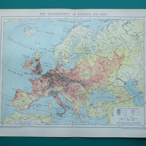 Può includere: Una mappa vintage dell'Europa del 1900 circa, con testo in tedesco. La mappa mostra la densità di popolazione, con colori che indicano diversi livelli. L'Oceano Atlantico e vari mari sono etichettati.