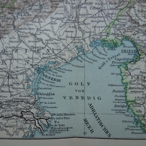 May include: Antique map fragment depicting the Adriatic Sea and surrounding regions, including Venice and Trieste. The map features detailed geographical features, with text labels in black and blue, and a light blue sea.