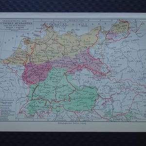 Op de afbeelding: Een vintage kaart van Duitsland, met regionale dialecten. De kaart gebruikt verschillende kleuren om dialectgebieden te onderscheiden, met Duitse tekst. De kaart is gedrukt op verouderd papier, met een schaal van 1:3.000.000.