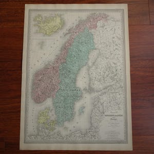 May include: An antique map of Scandinavia, showing countries in pink, green, and yellow. The map has French text and a decorative border. It is printed on aged paper.