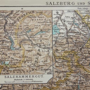 Può includere: Una mappa vintage dettagliata delle regioni di Salisburgo e Salzkammergut in Austria. La mappa presenta dettagli topografici, tra cui montagne, laghi e fiumi, con nomi di luoghi in tedesco. La scala della mappa è 1:500.000.